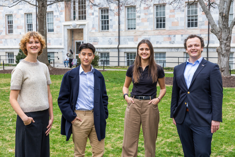 Picture of 4 students standing in front of a building